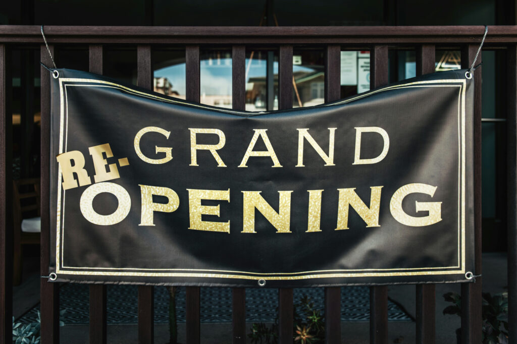 A black banner with golden letters saying re-grand opening.